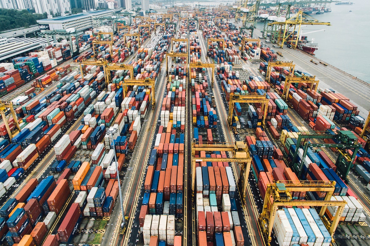 A large number of shipping containers in a busy cargo port.