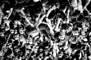 Photograph taken by Lewis Evans showing a band member crowd-surfing.